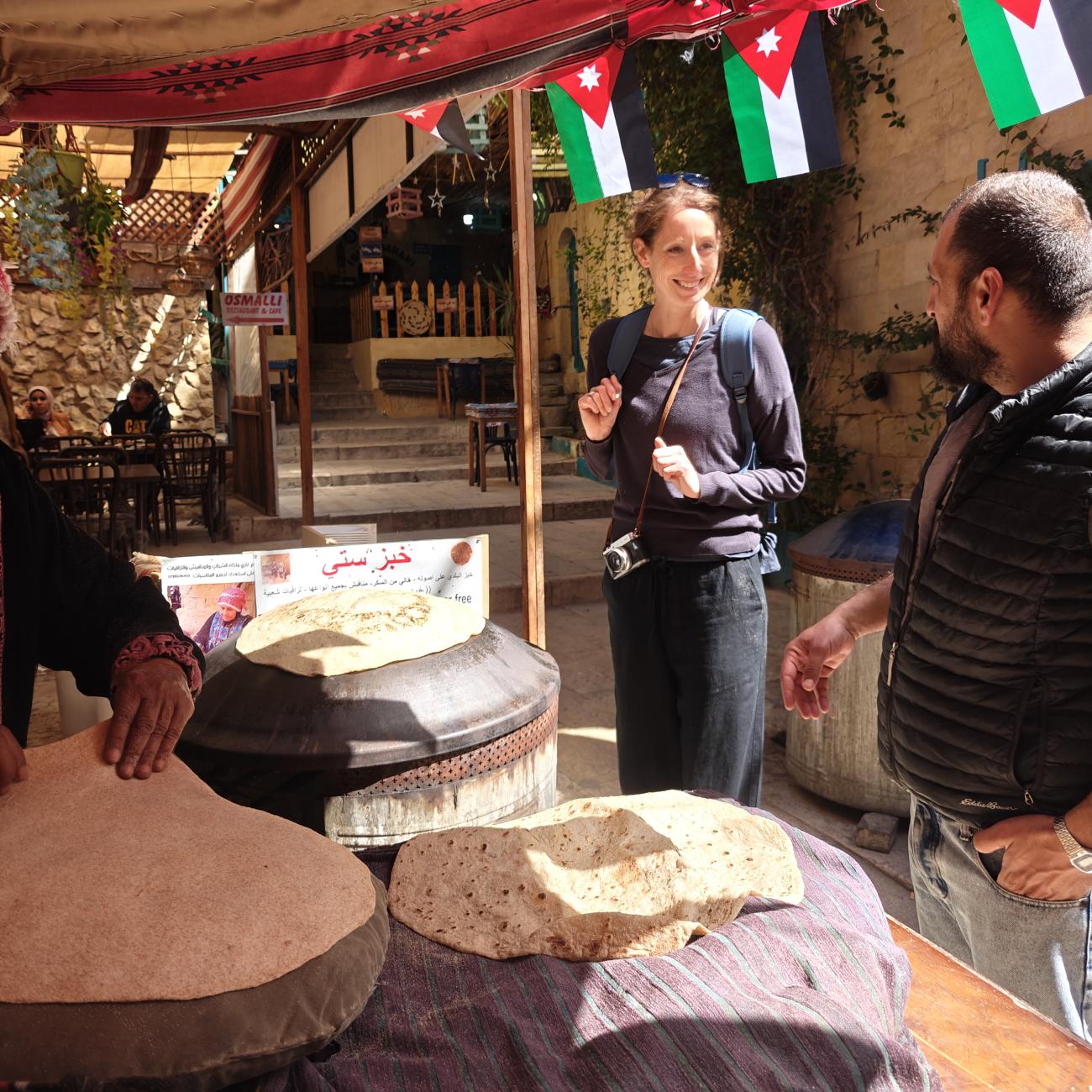 Jordanian saj flat bread making with man and woman stood in front of stall