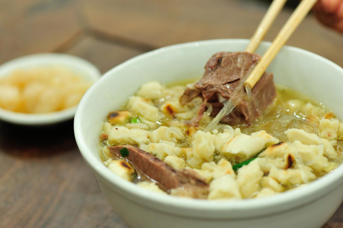 Closeup of chopsticks in a Chinese soup called paomo