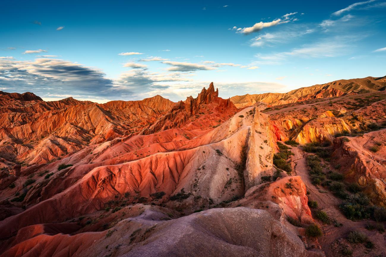 Fairy Tale Canyon in Kyrgyzstan. Red rock formations during sunset with blue sky